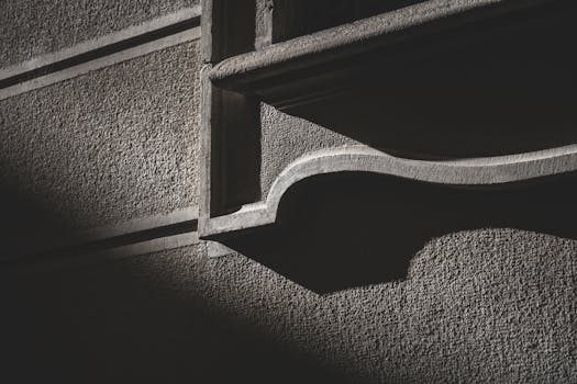 Dramatic shadows on a textured concrete wall create urban contrast.