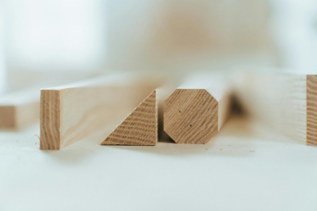 A close-up view of various wooden pieces in geometric shapes on a workshop table.